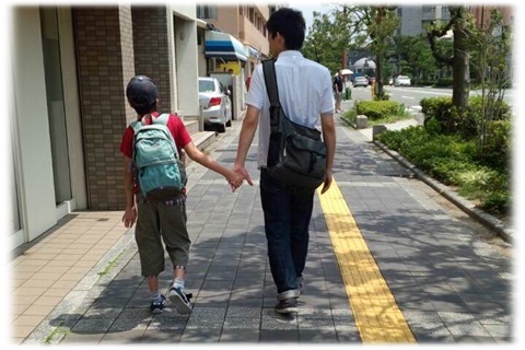 ヘルパーが児童利用者と歩道を歩いている写真